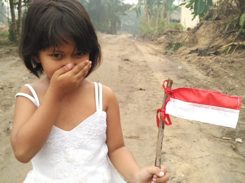 petite fille tenant un drapeau indonésien