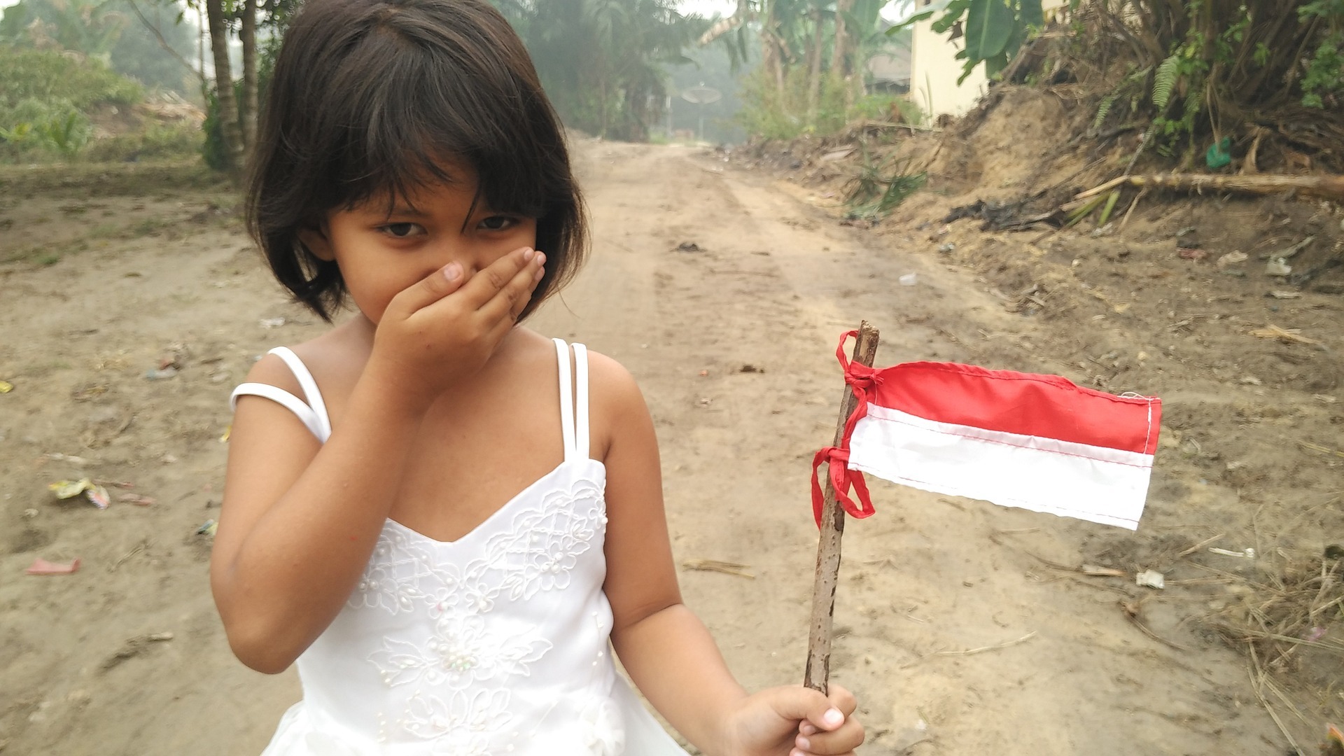 petite fille tenant un drapeau indonésien
